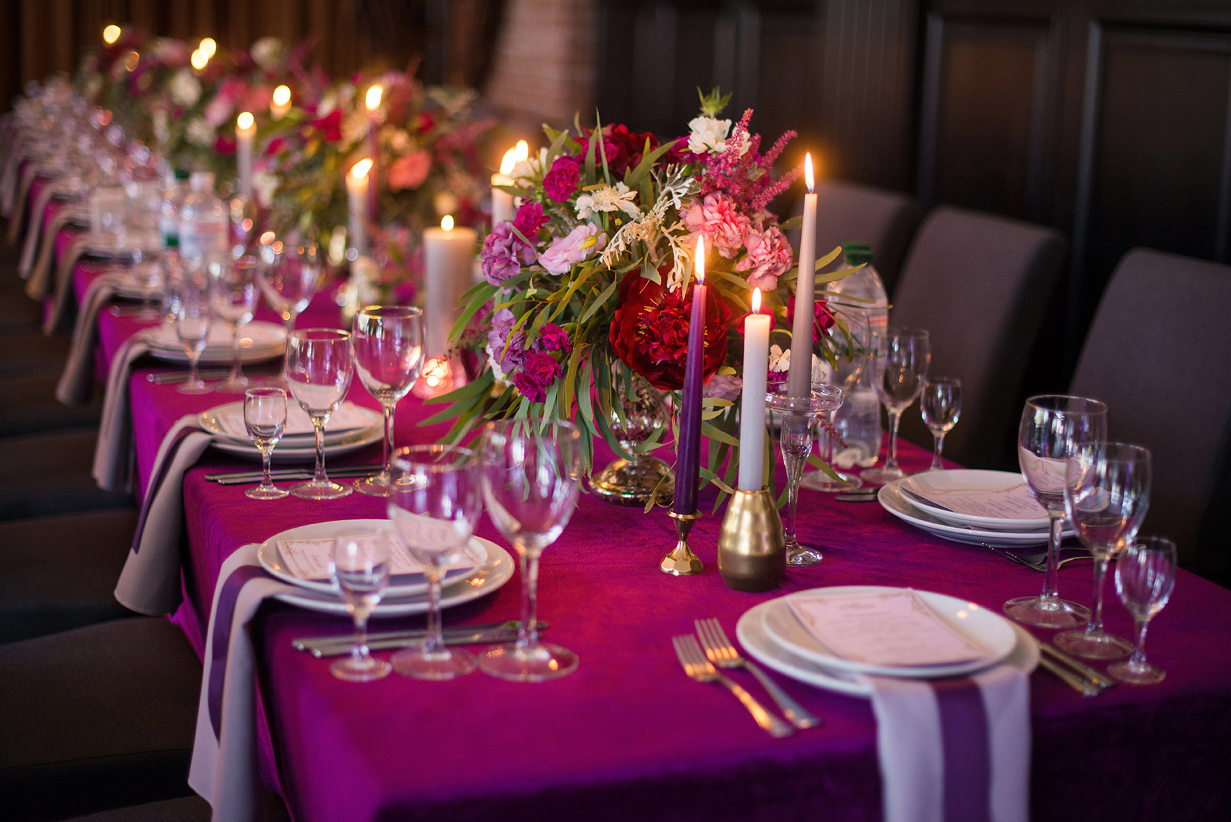 Tablescape with magenta tablecloth crystal and candlelight